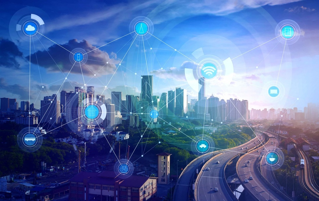 Et moderne bybilde med motorveier og skyskrapere overlagt med et nettverk av digitale forbindelser, ikoner som representerer ulike teknologier (skytjenester, wifi, enheter og data), og visualiserte datastrømmer.